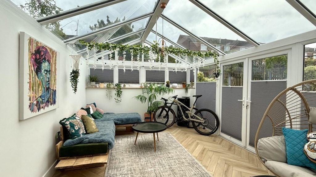 Bright and Inviting Modern Sunroom Retreat Modern sunroom with glass roof, vibrant decor, and plants for a bright, inviting space.