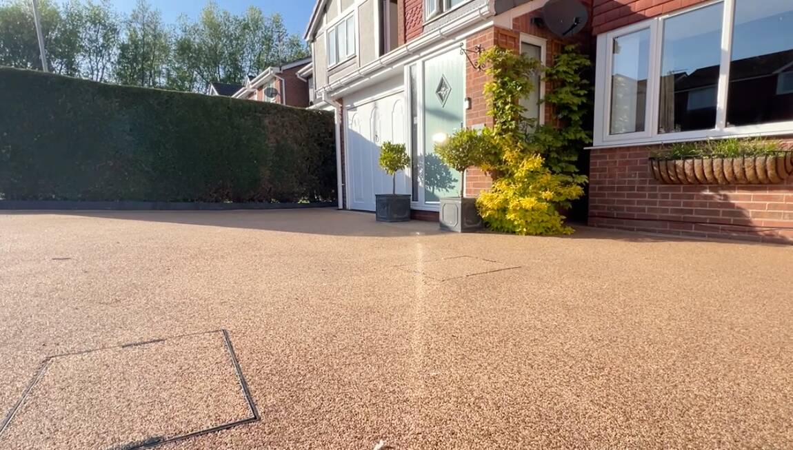Clean driveway with decorative plants.