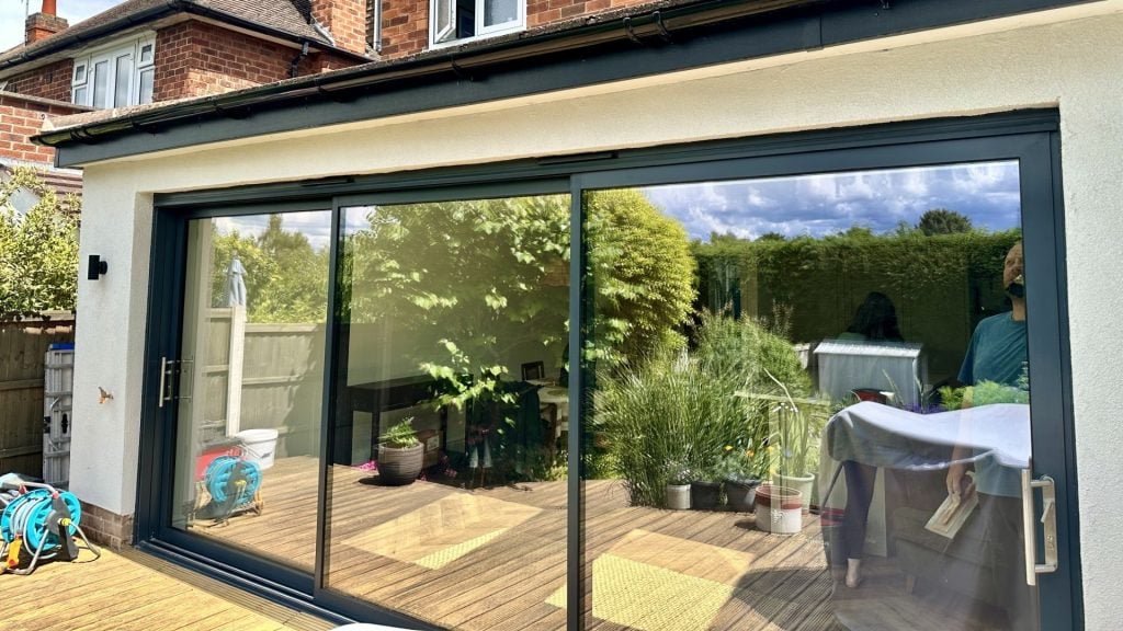 Cozy Modern Home Extension with Garden View Modern home extension with sliding glass doors and a beautiful outdoor deck for relaxation.