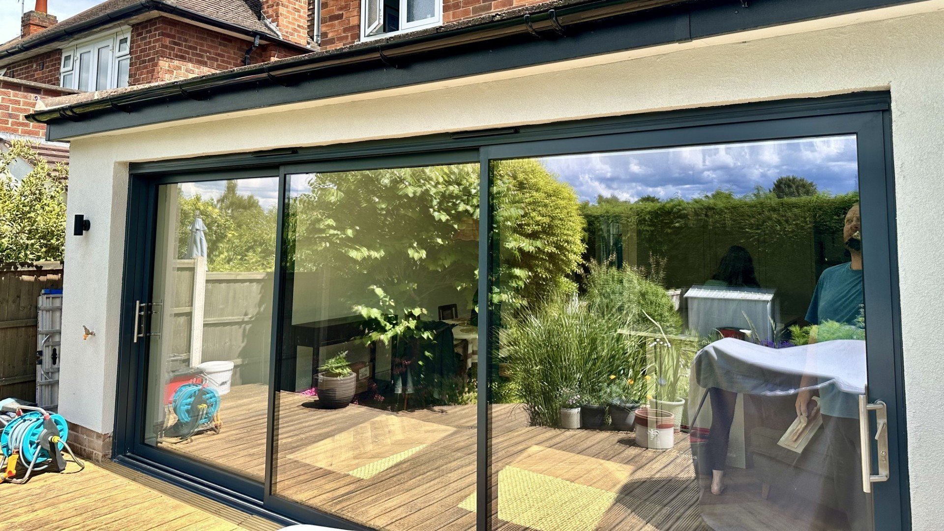 Cozy Modern Home Extension with Garden View Modern home extension with sliding glass doors and a beautiful outdoor deck for relaxation.