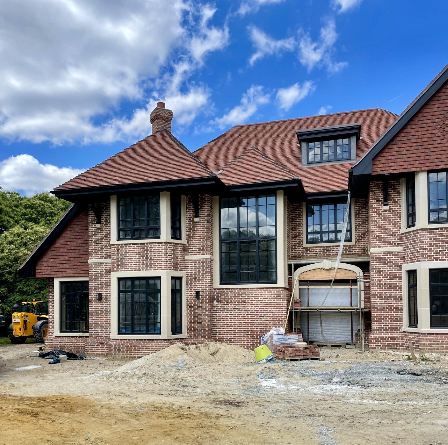 Elegant new build home with red brick and modern accents in early construction phase.