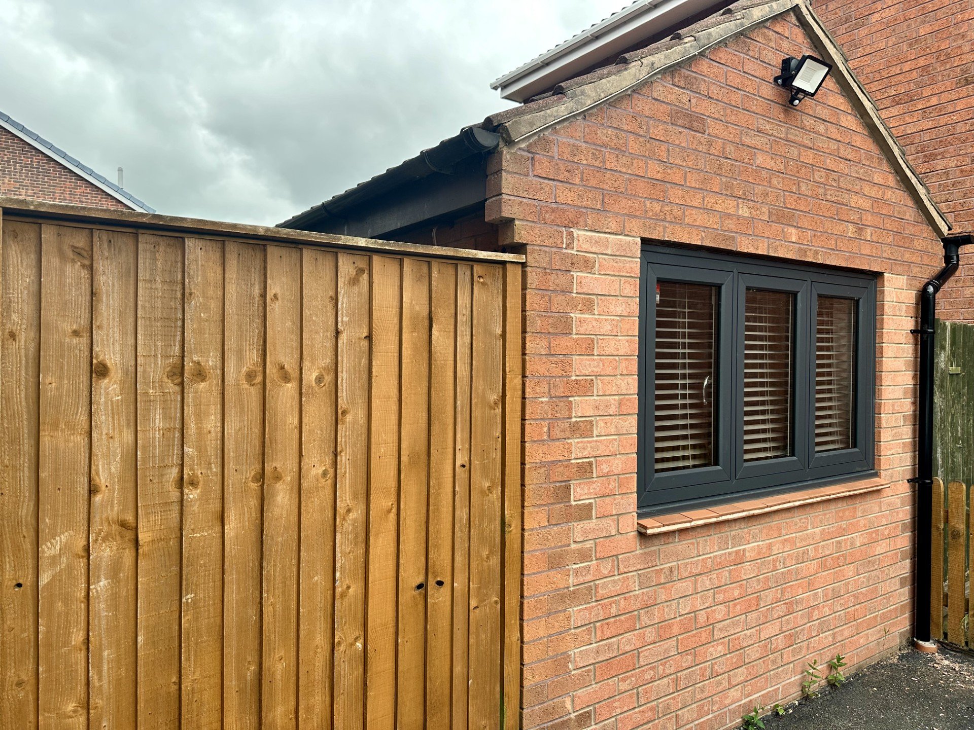 Brick garage with wooden fence entrance